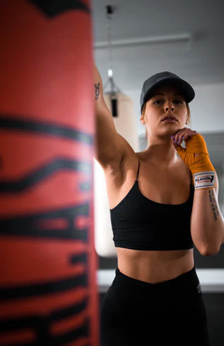 chica boxeando en su propia casa con un saco de boxeo